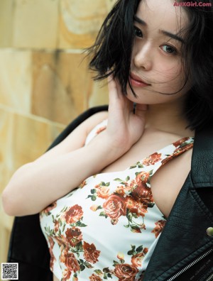 A woman in a black lingerie sitting on a bed.