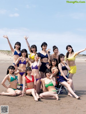 A group of women in bikinis standing on a beach.