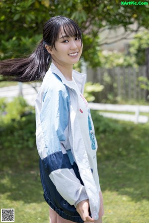 A woman standing on top of a wooden bench.