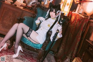 A woman in a cat costume sitting on a chair.