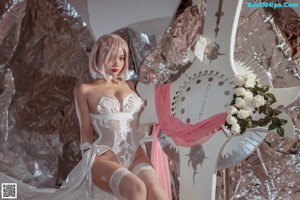 A woman sitting on top of a bed covered in silver foil.