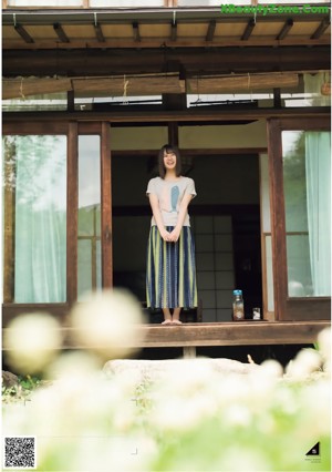 A woman in a blue shirt smiles at the camera.