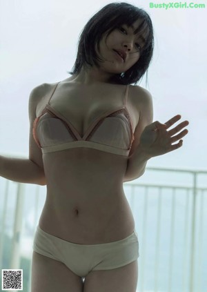 A woman laying on top of a bed in a green bra.