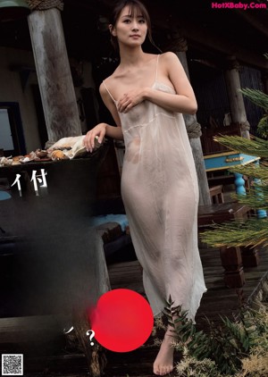 A naked woman sitting on the floor in front of a window.