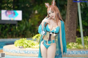 A woman in a blue dress sitting in a pool.