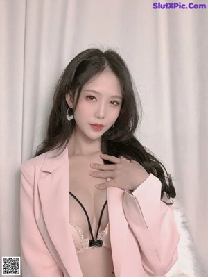 a woman in a pink suit posing for the camera