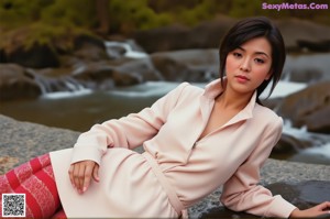 A woman in a pink dress sitting on a red couch.