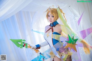 A woman in a blue and gold outfit holding a sword.