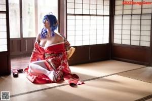 A woman in a red kimono sitting on a tatami mat.