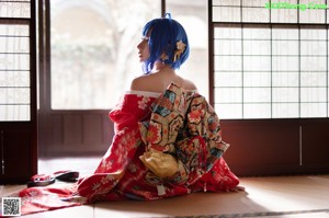 A woman in a red kimono posing for a picture.