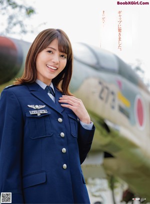 A woman in a military uniform laying on the grass.