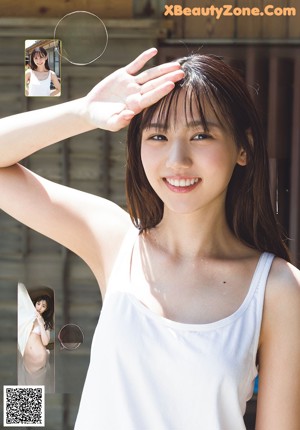 A woman in a white tank top posing for a picture.