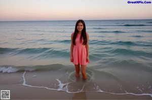 A naked asian woman posing in front of the ocean.