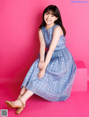 A woman with long black hair and bangs is posing for a magazine.