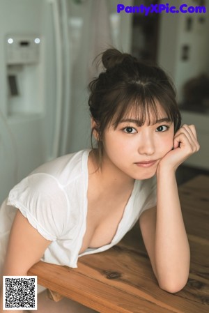 A woman in a white shirt and blue panties posing for a magazine.