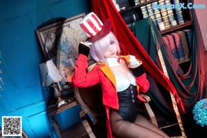 A woman in a red jacket and black stockings sitting on a chair.