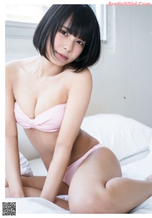 A woman in a bathing suit sitting on a chair.