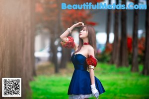 A woman in a red skirt and white top posing for a picture.
