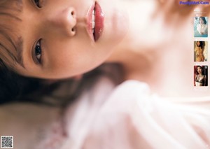 A woman in a white shirt is laying down on a bed.