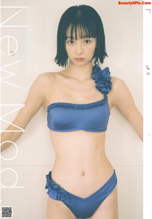 A woman in a blue bikini standing on a ladder.