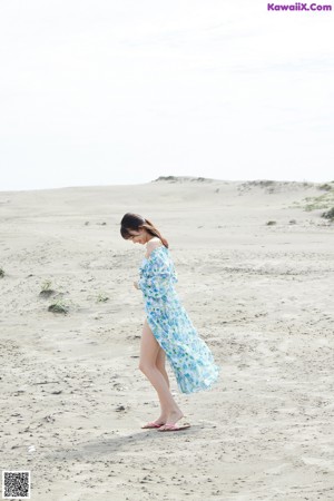 A woman in a blue dress is walking up some stairs.