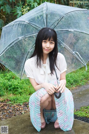 A woman with long black hair wearing a white shirt.